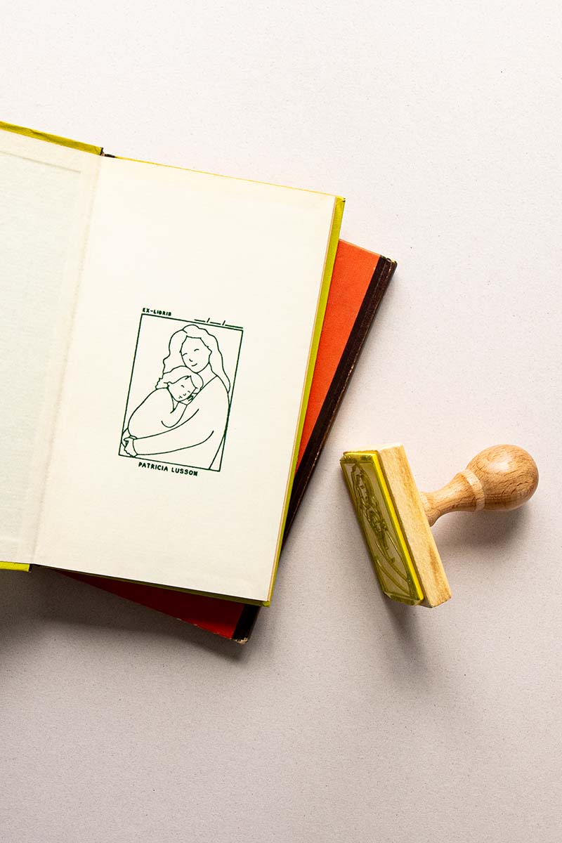 Portadilla de libro estampado con sello exlibris con madre y hijo dándose un abrazo