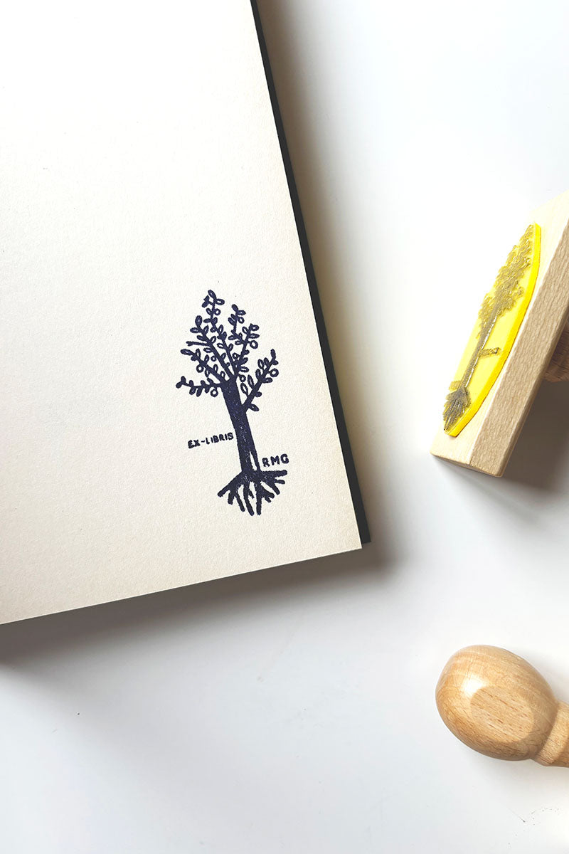 Portadilla de un libro estampada con un árbol geométrico y sello