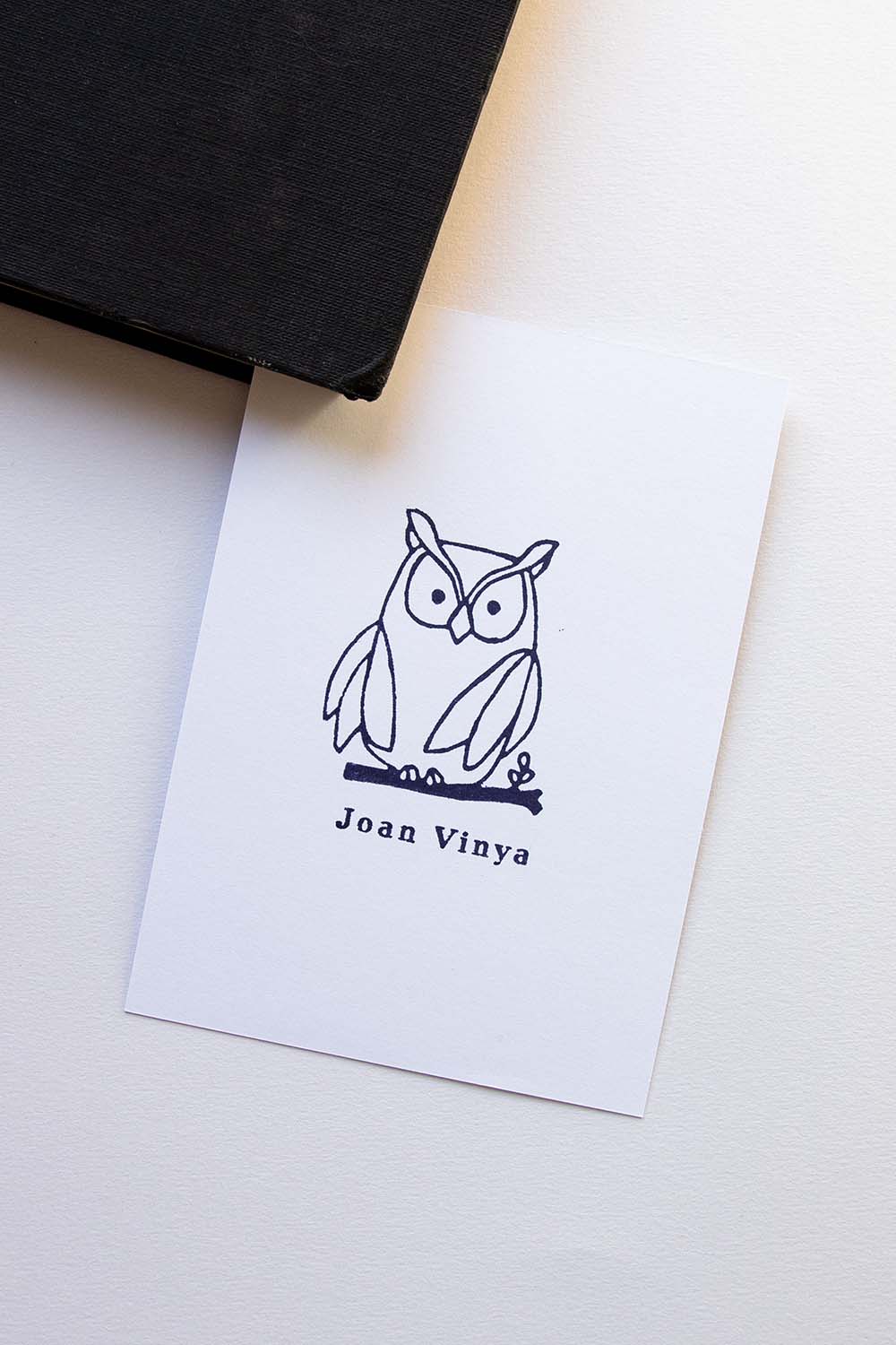 Portadilla de libro estampada con sello exlibris de un búho encima de una rama