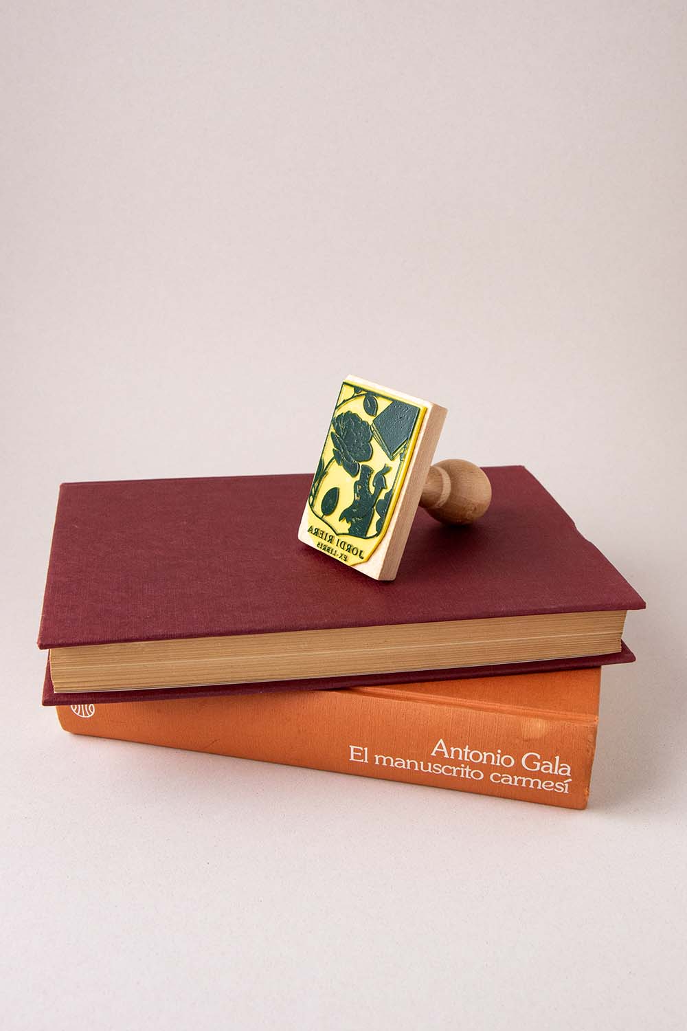 Sello ex-libris de un escudo con una rosa, un libro y un dragón