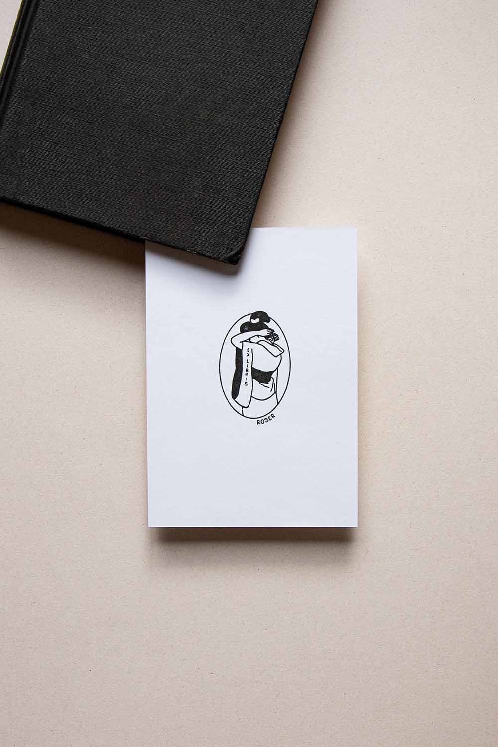 Portadilla de libro estampada con sello exlibris de una mujer vestida con Kimono