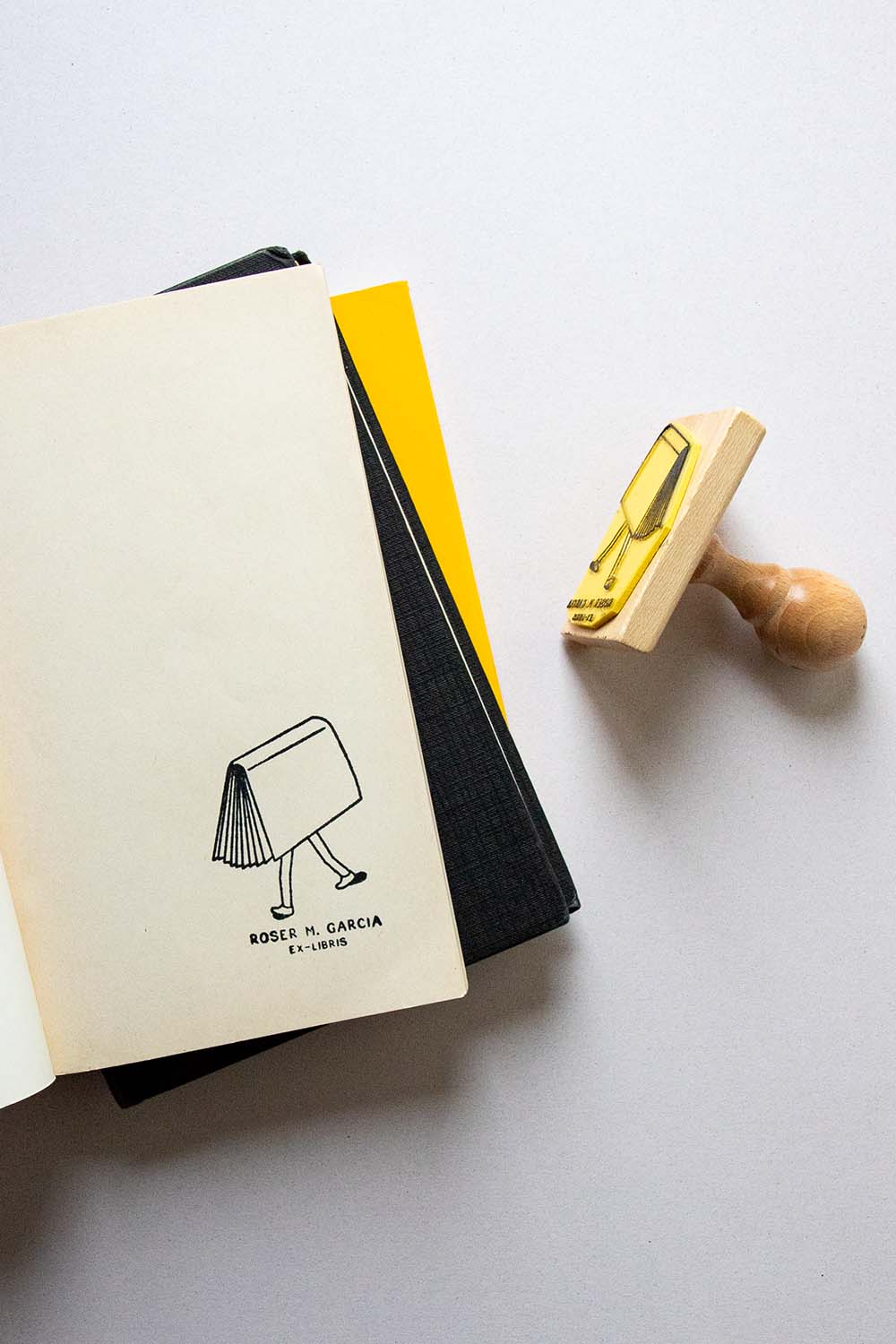 Portadilla de libro estampada con sello exlibris de un libro con piernas humanas caminando y sello