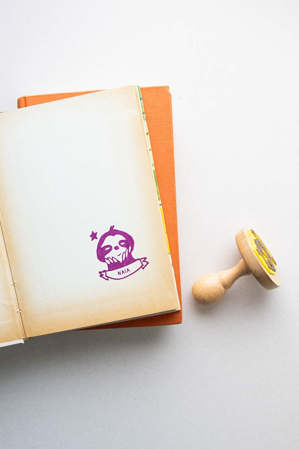 Página de libro estampada con un sello exlibris de un perezoso y sello