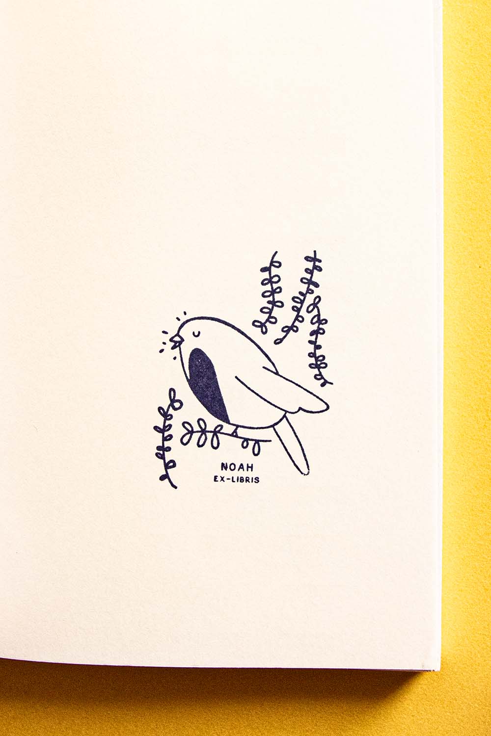 Portadilla de libro estampada con sello exlibris de un pájaro petirrojo cantando
