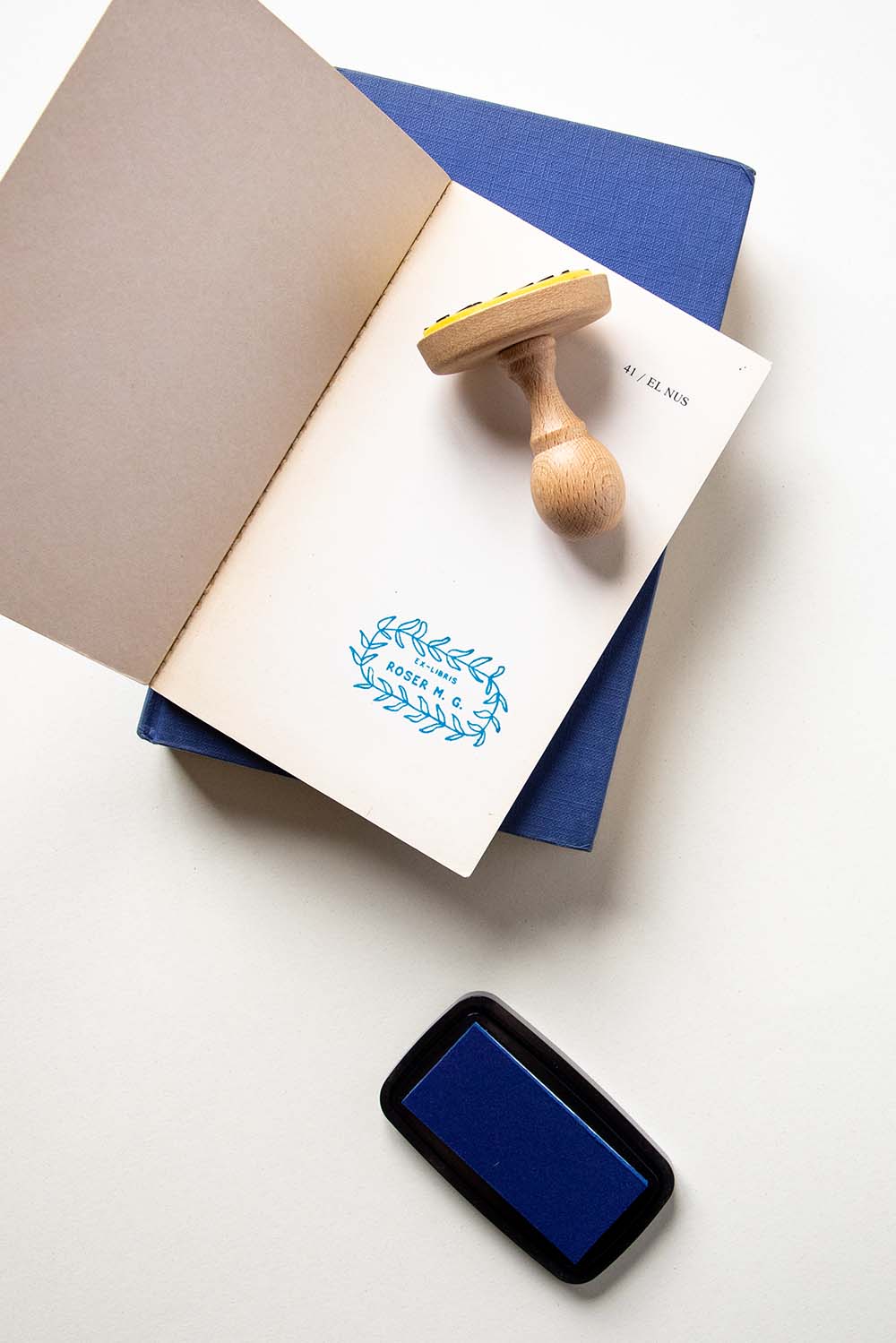 Portadilla de libro estampada con sello exlibris de una corona de hiedra y sello