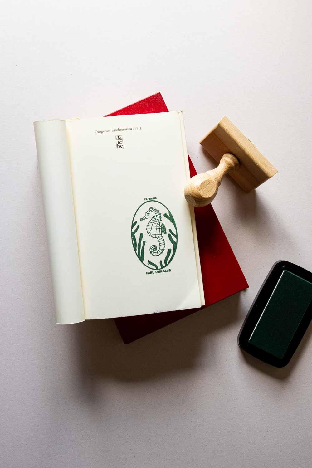 Portadilla de libro estampado con sello exlibris con un caballito de mar