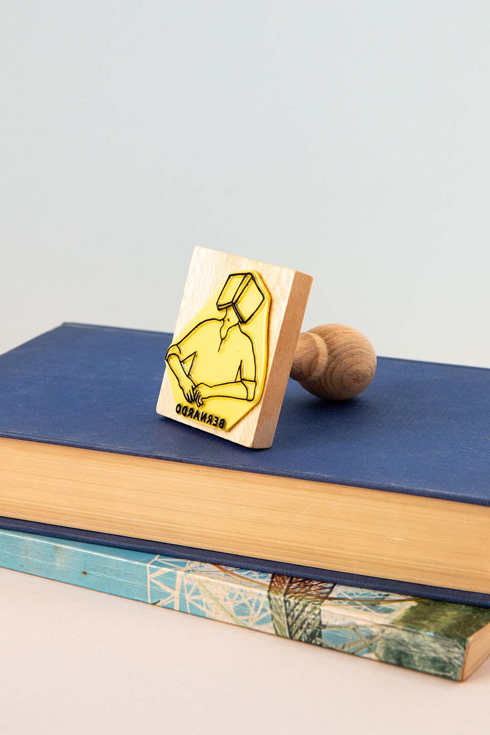 Sello ex-libris con una persona dormiendo con un libro abierto encima de su cara