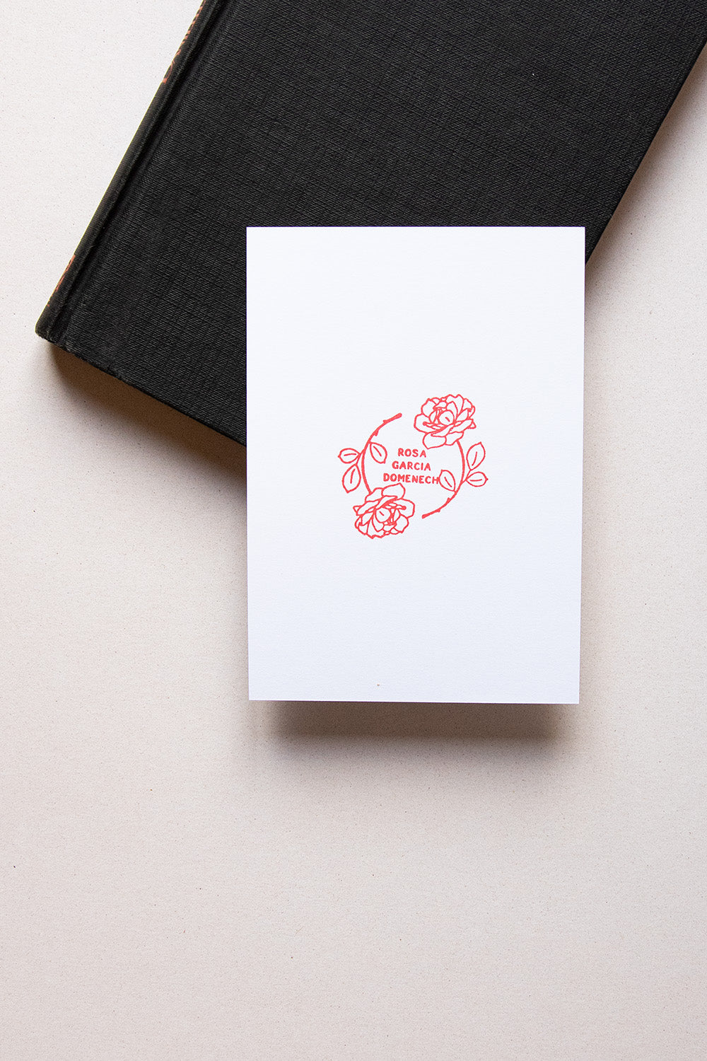 Portadilla de libro estampada con sello exlibris de dos rosas que crean un círculo