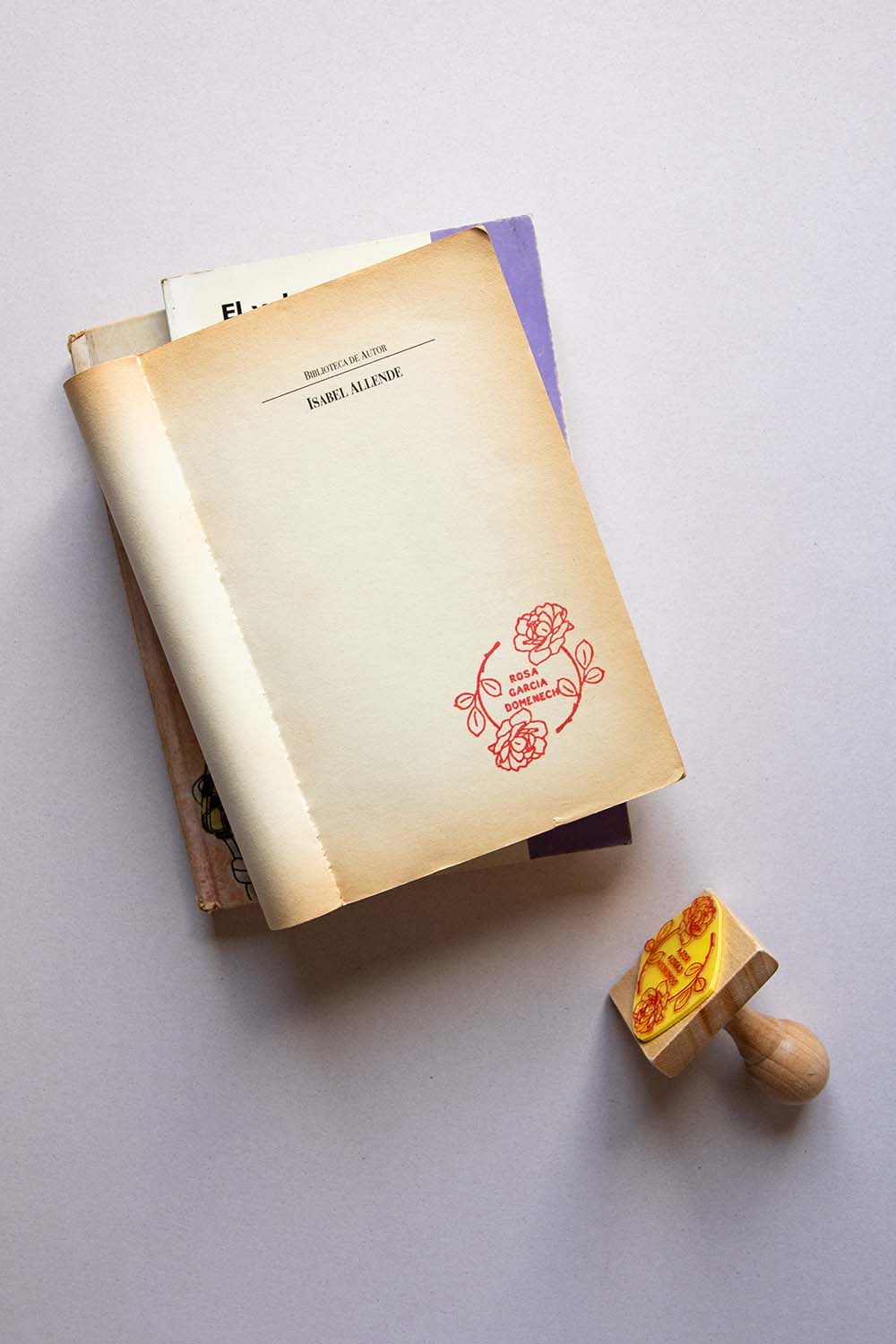 Portadilla de libro estampada con sello exlibris de dos rosas que crean un círculo y sello