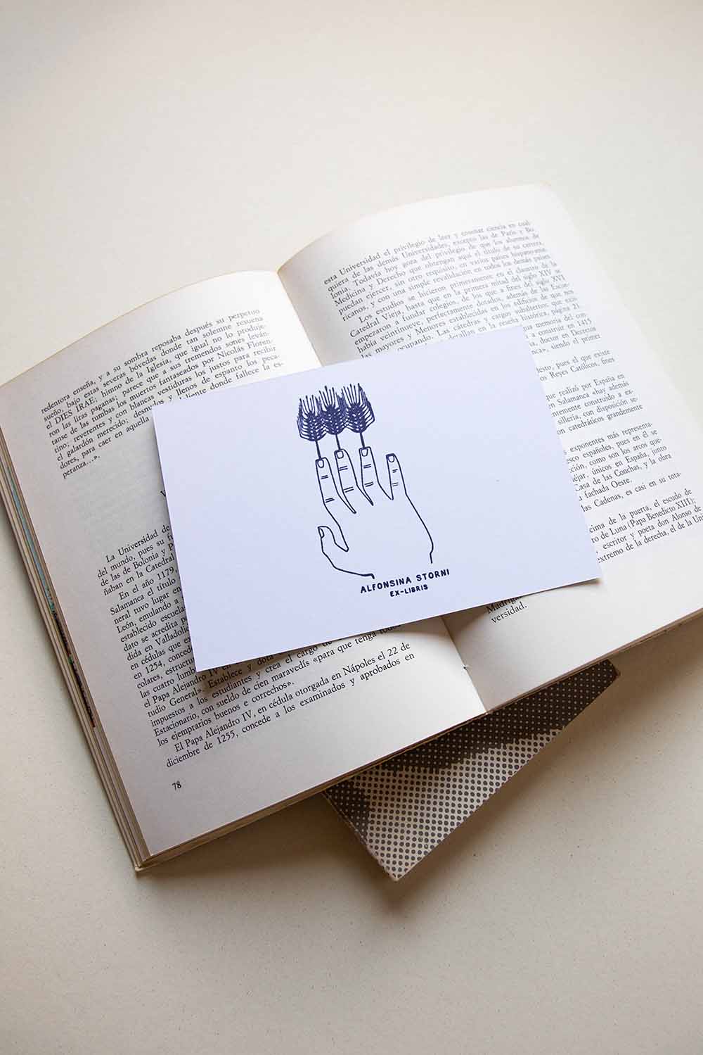 Portadilla de libro estampada con sello exlibris de una mano con tallos de trigo a modo de dedos