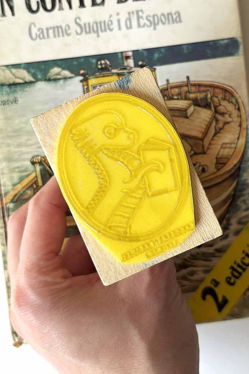 Sello ex-libris de un dragón leyendo