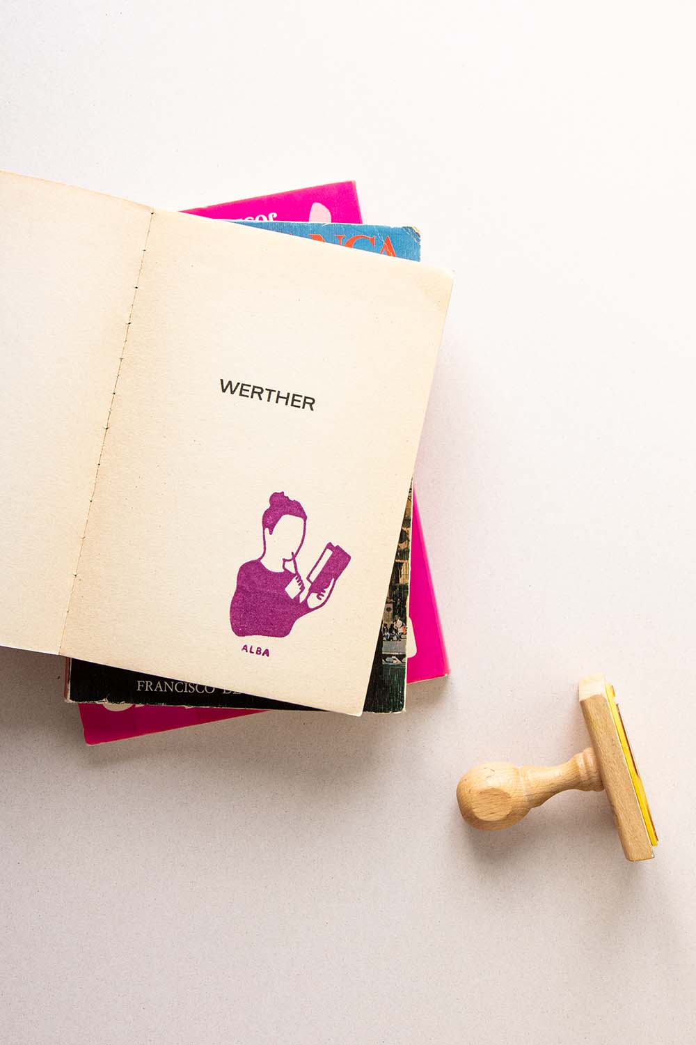 Portadilla de libro estampada con sello exlibris de persona leyendo con un lapiz en la mano y sello