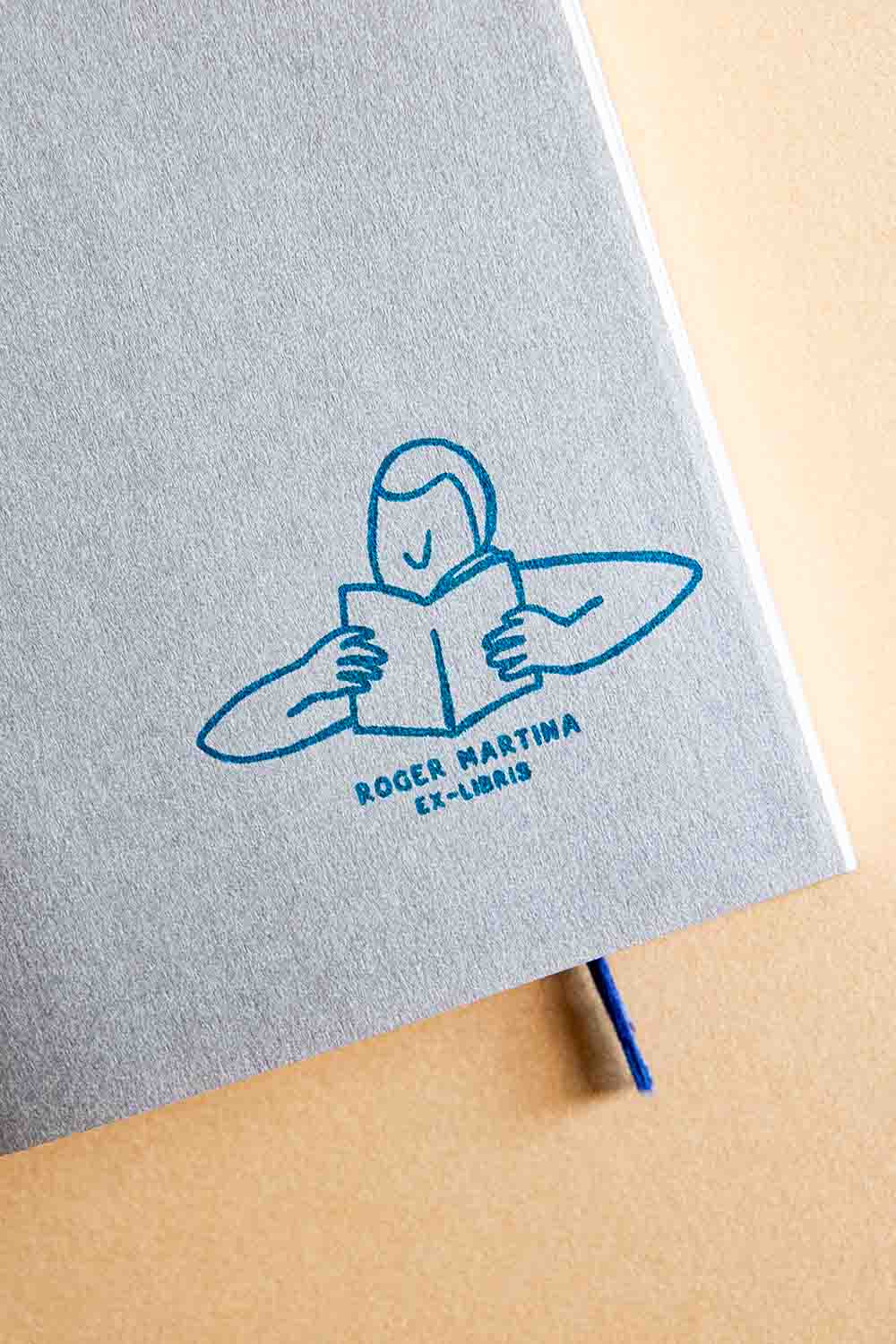 Portadilla de libro estampada con un lector absorto en la lectura de un libro