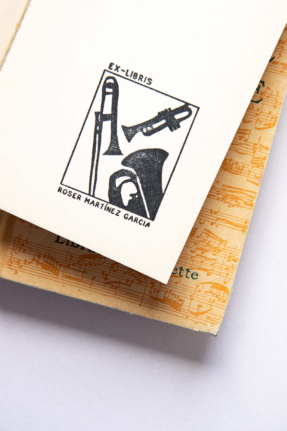 Portadilla de libro estampado con sello exlibris con trompeta, trombón y bombardino