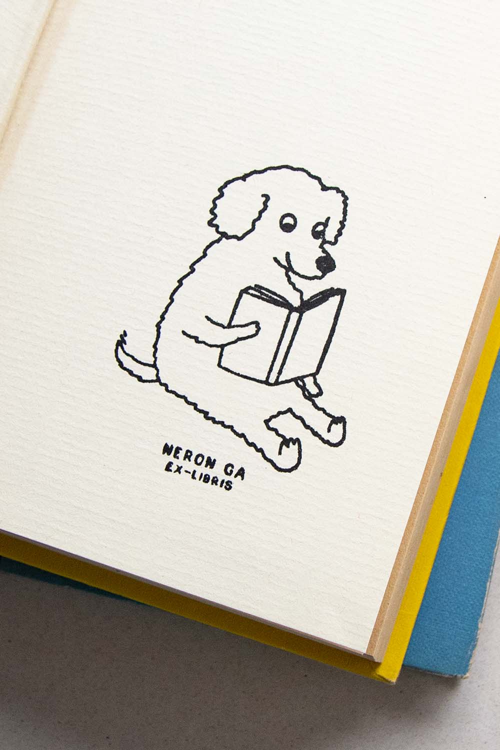Portadilla de libro estampado con sello exlibris de un perro lector