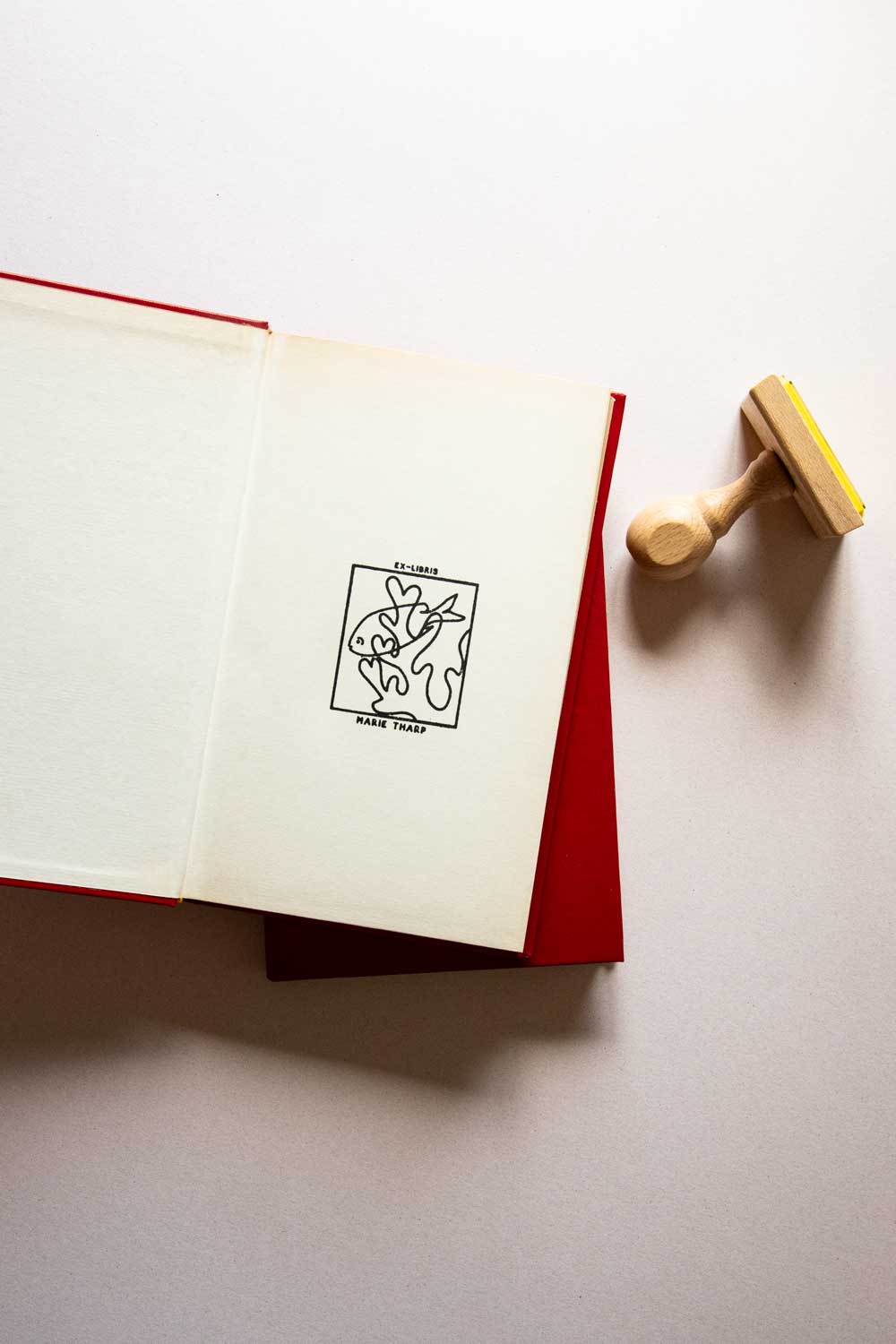 Portadilla de libro estampado con sello exlibris con pez en un coral