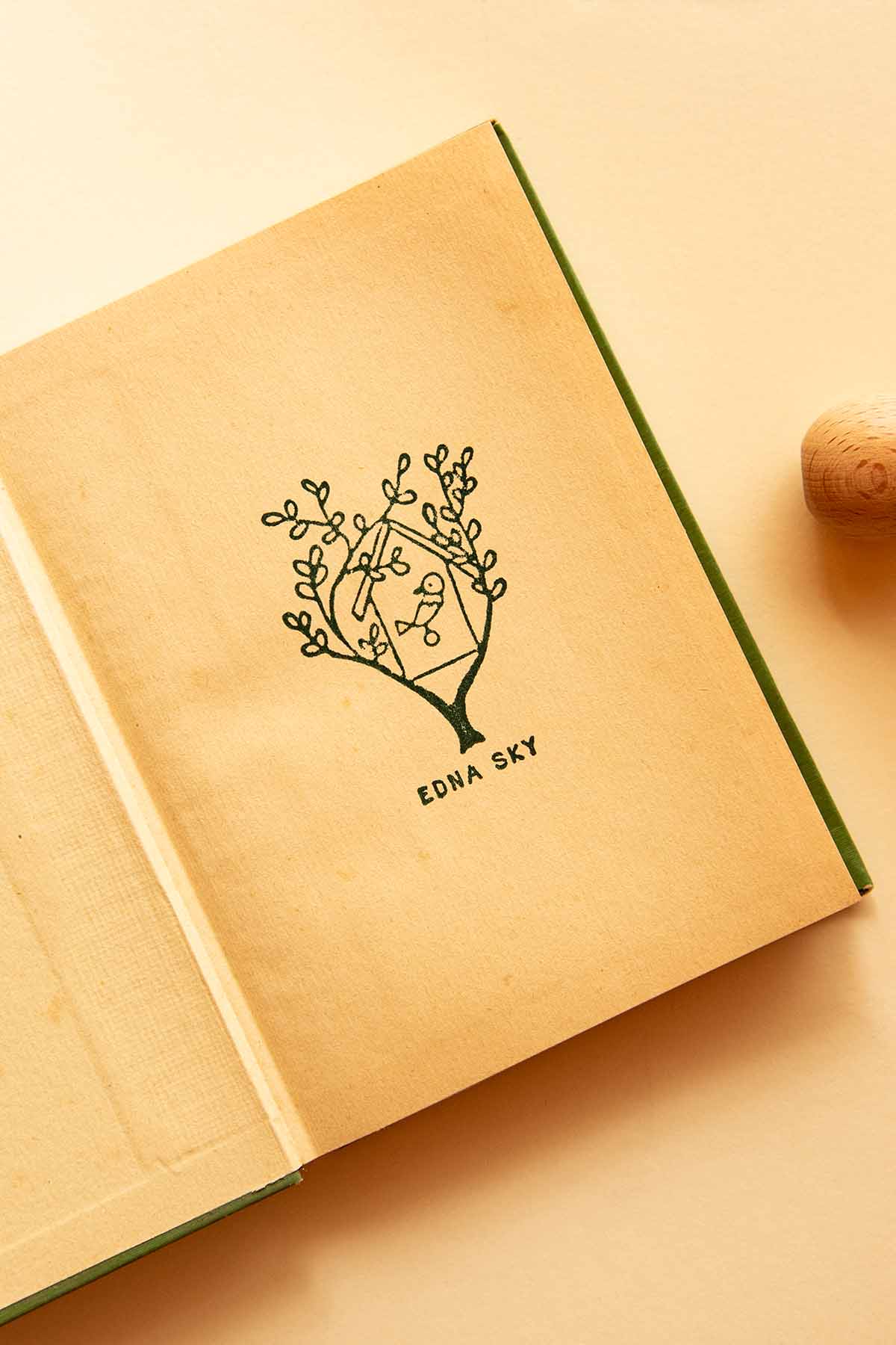 Portadilla de libro estampada con sello exlibris de una casita de pájaro
