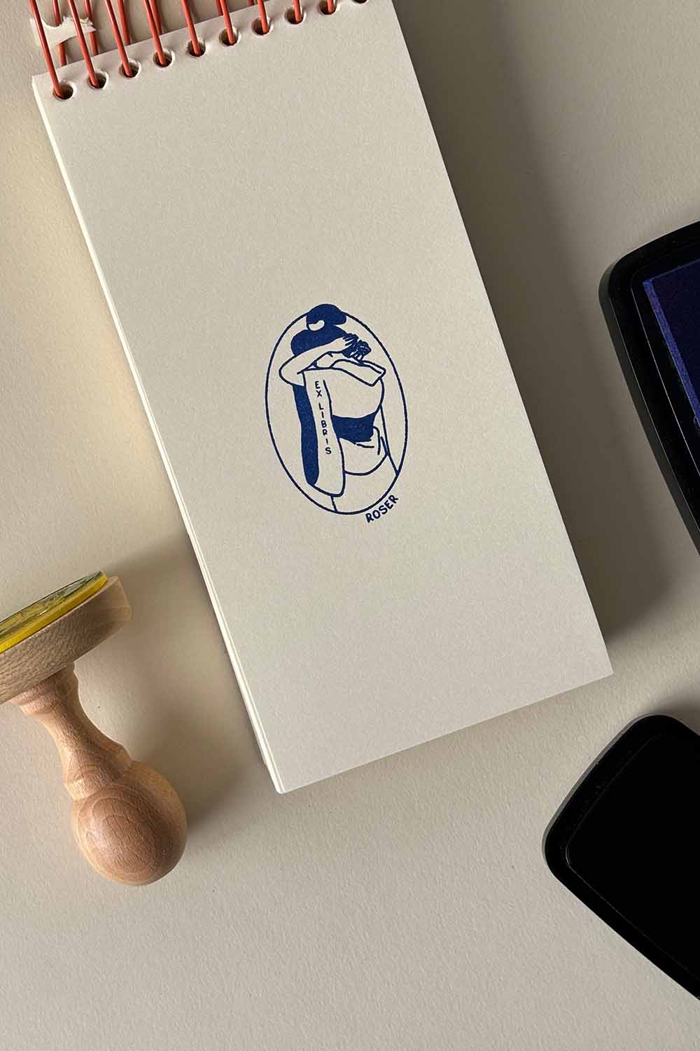 Portadilla de libro estampada con sello exlibris de una mujer vestida con Kimono y sello