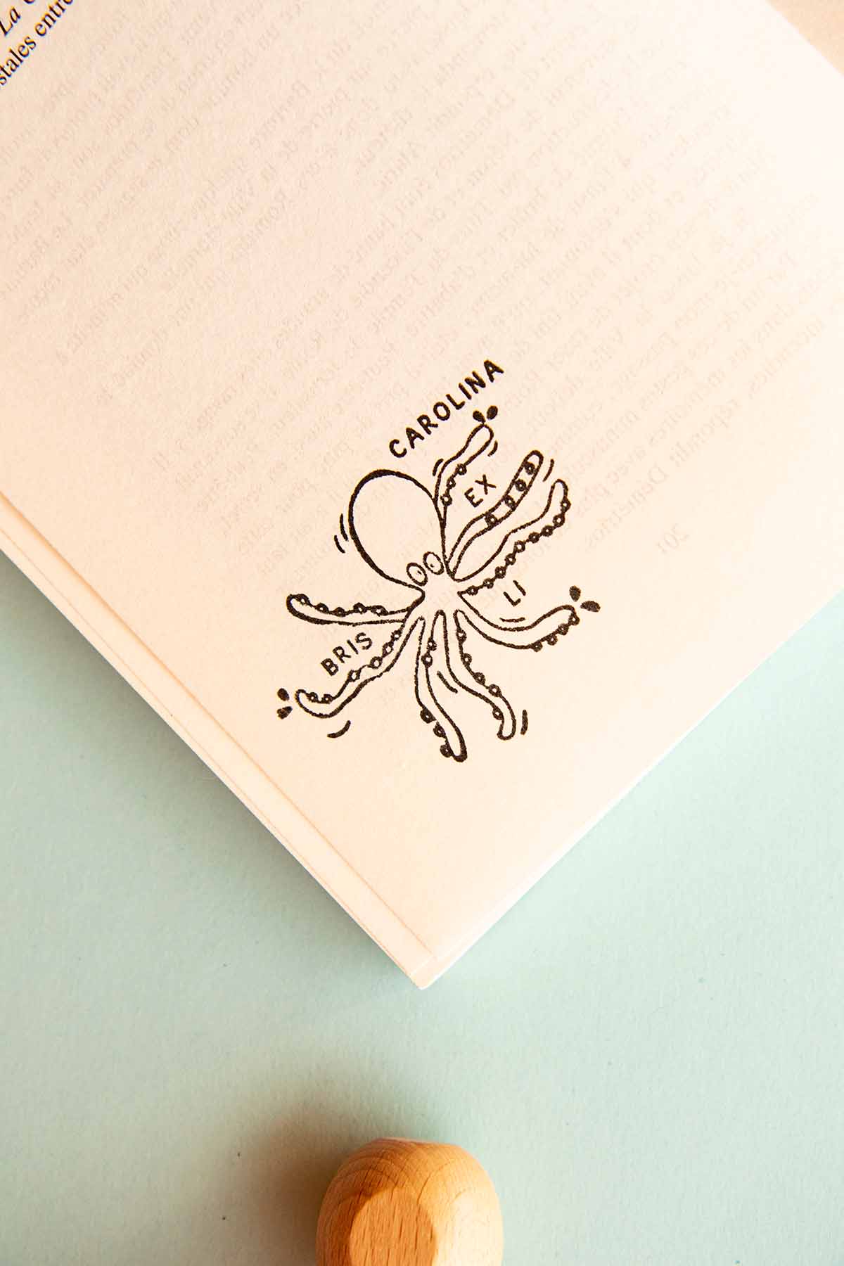 Página de libro estampada con un sello exlibris de un pulpo